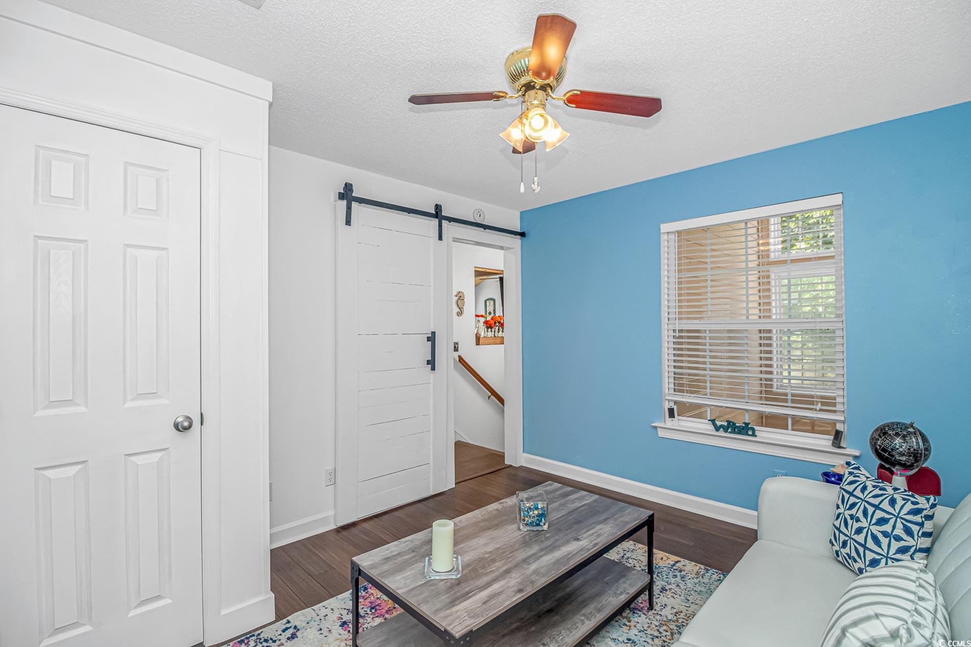 4394 Daphne Lane, Unit G Murrells Inlet, SC 29576 - Photo 17 of 30 Living room featuring a barn door, a textured ceiling, dark wood-style flooring, and ceiling fan