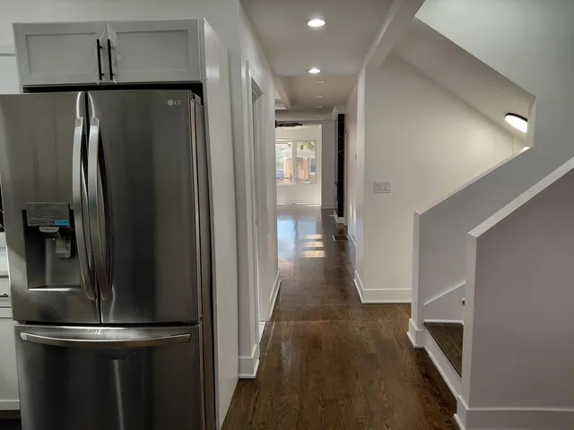 a view of a refrigerator in kitchen and an empty room