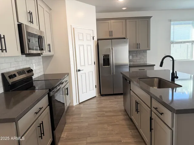 a kitchen with granite countertop a sink and refrigerator