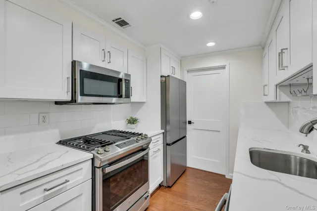 a kitchen with stainless steel appliances granite countertop a sink stove and refrigerator