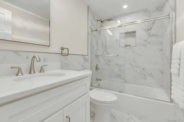 a bathroom with a sink mirror toilet and bathtub