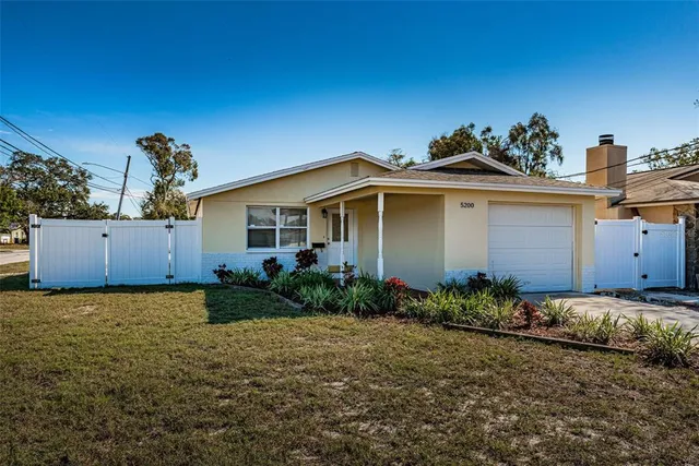 a view of a house with a yard and potted plants