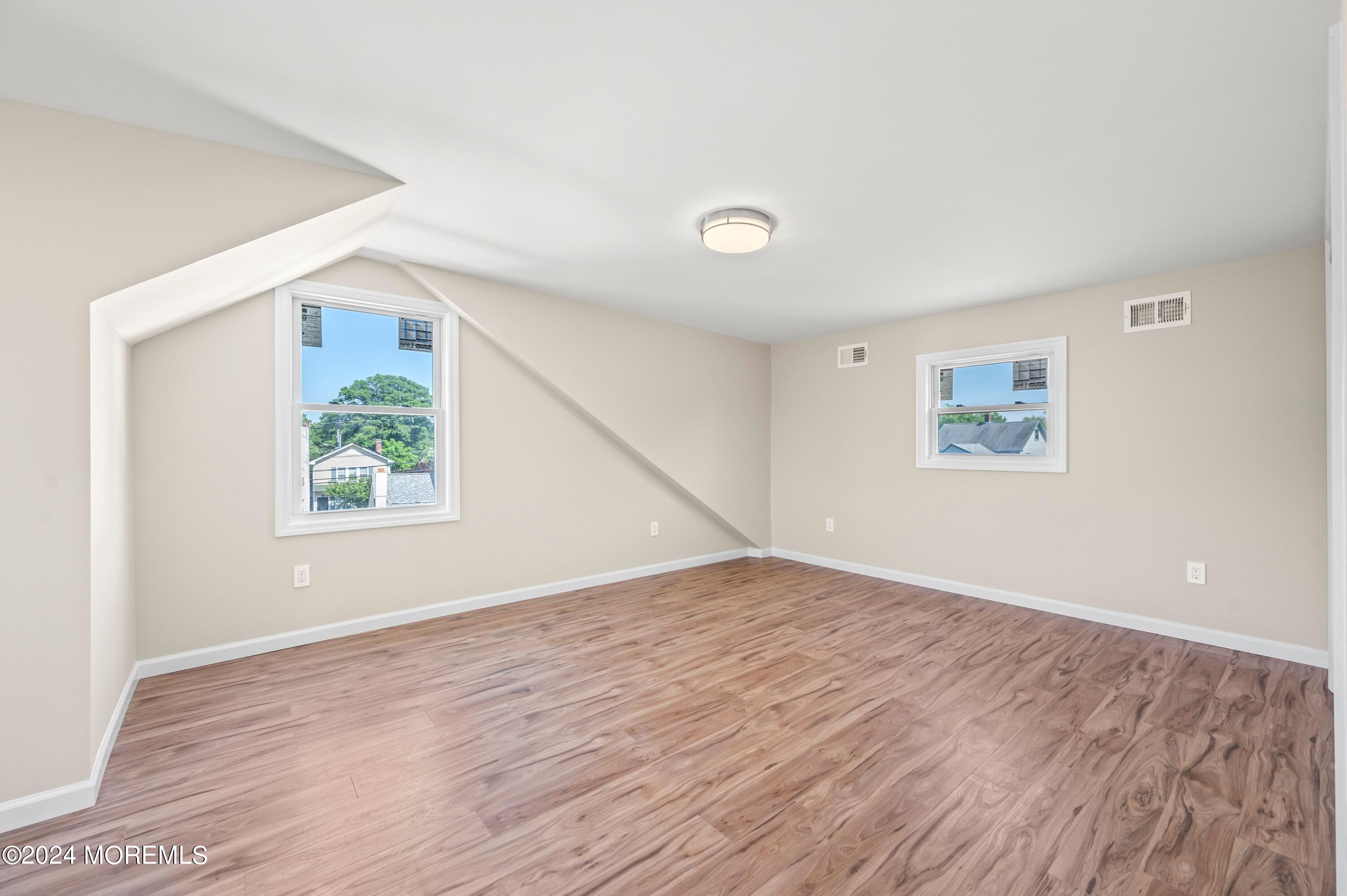 124 Victoria Place Union Beach, NJ 07735 - Photo 11 of 29 an empty room with wooden floor and window