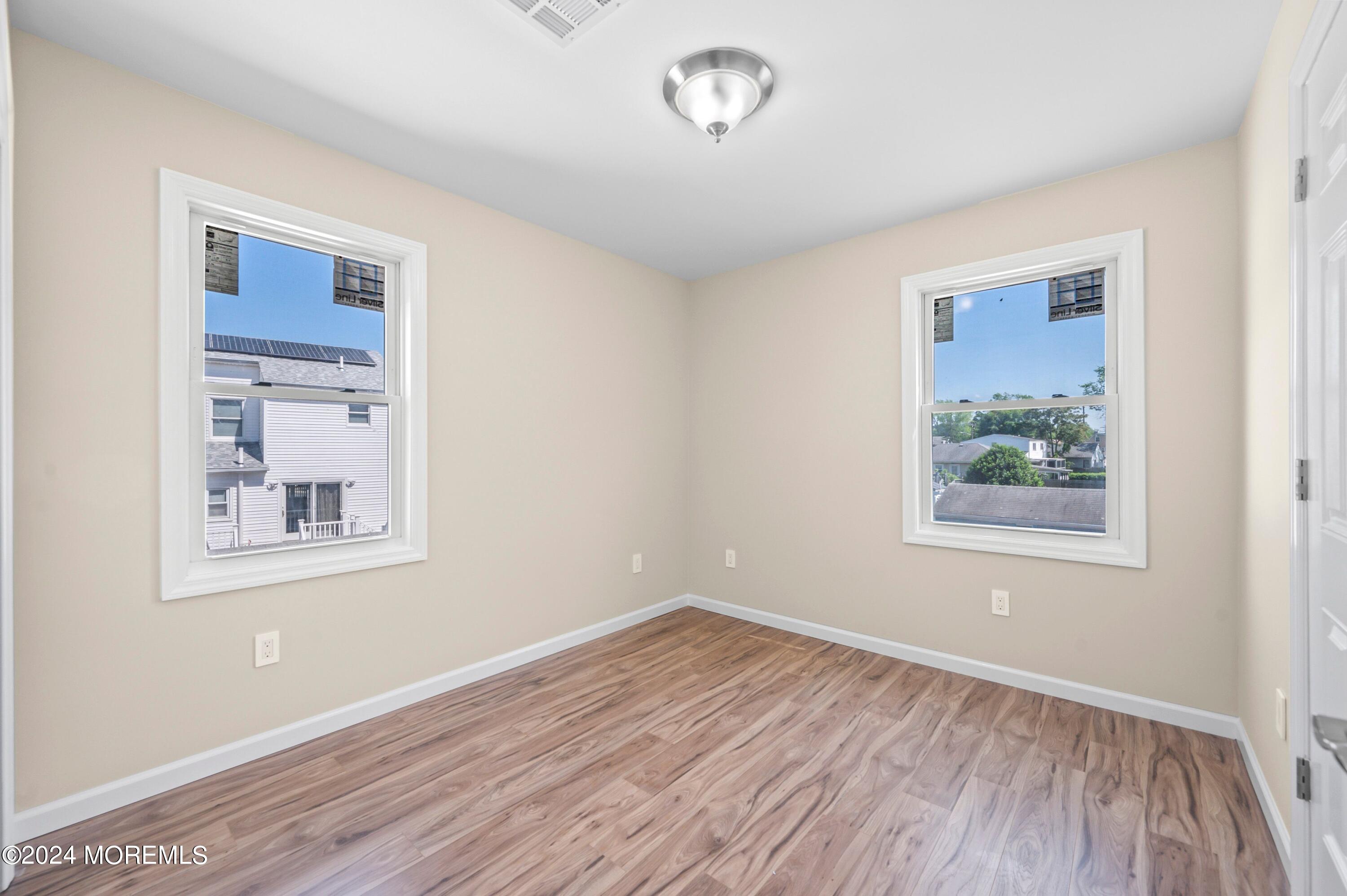 124 Victoria Place Union Beach, NJ 07735 - Photo 14 of 29 a view of an empty room with wooden floor and a window