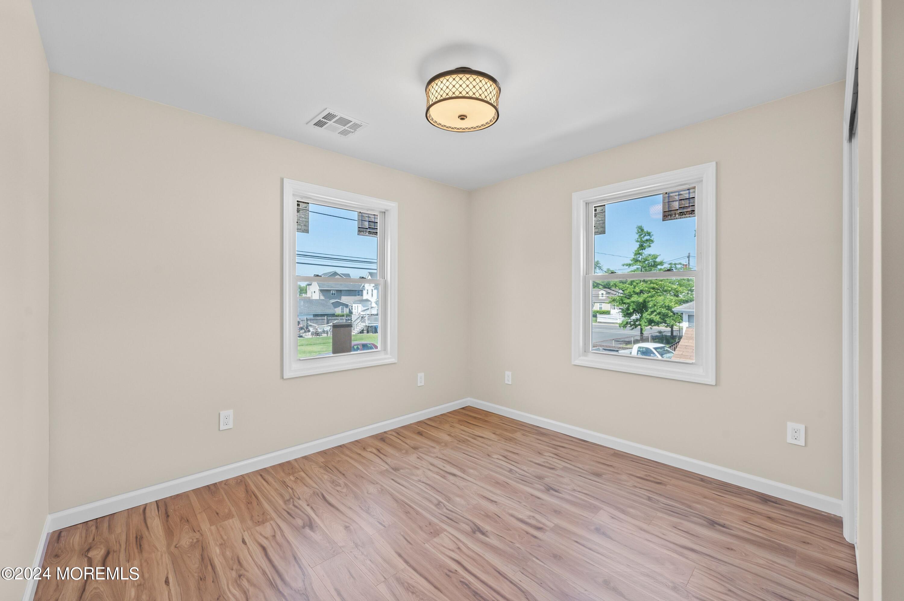 124 Victoria Place Union Beach, NJ 07735 - Photo 16 of 29 a view of an empty room with wooden floor and a window