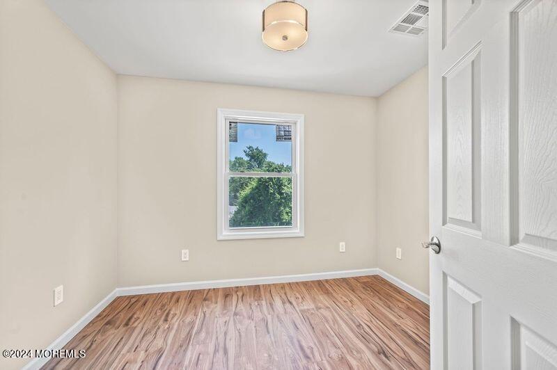 124 Victoria Place Union Beach, NJ 07735 - Photo 17 of 29 a view of an empty room with wooden floor and a window