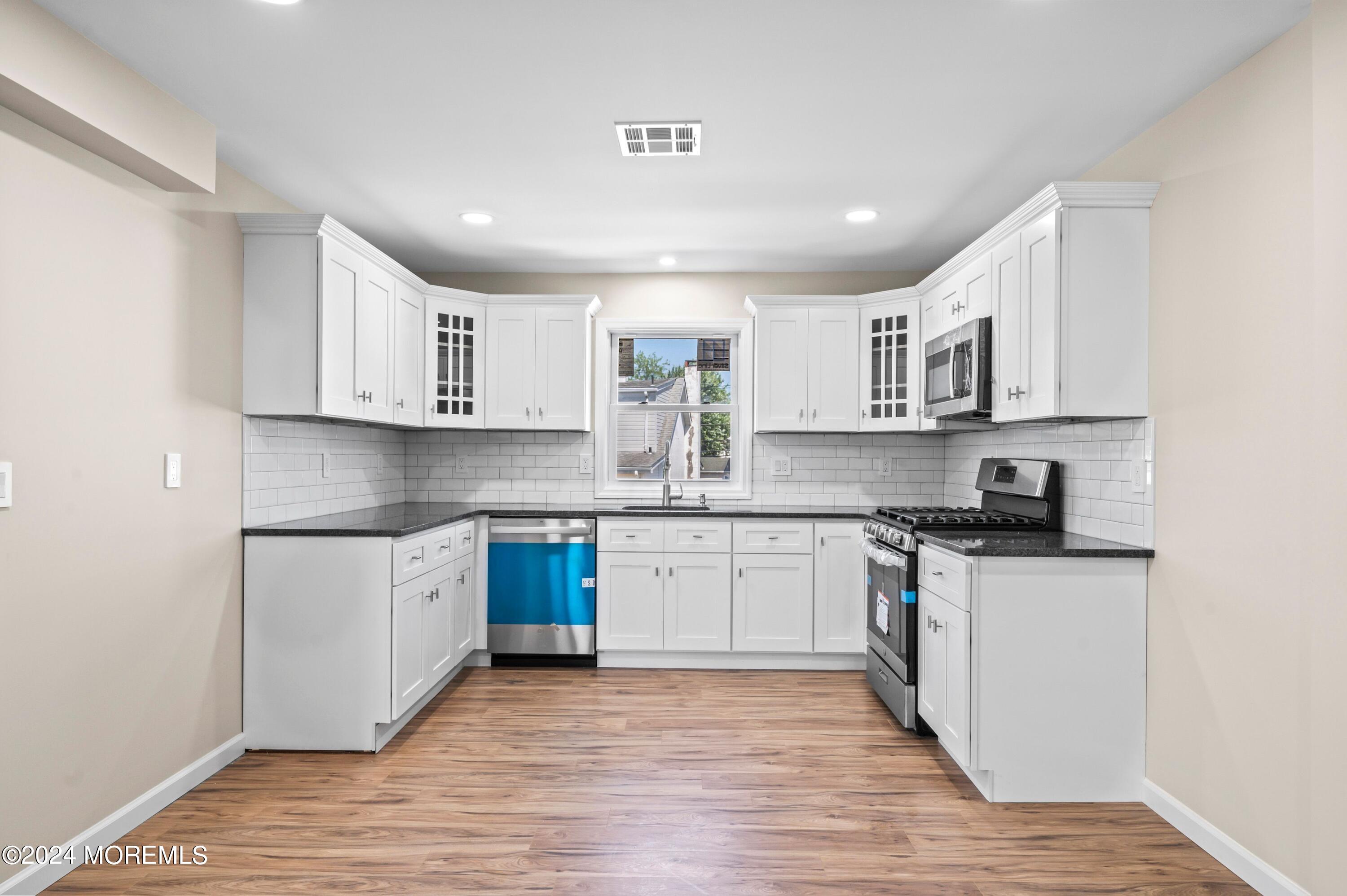 124 Victoria Place Union Beach, NJ 07735 - Photo 5 of 29 a kitchen with stainless steel appliances granite countertop a stove top oven a sink dishwasher and a microwave oven on granite countertops
