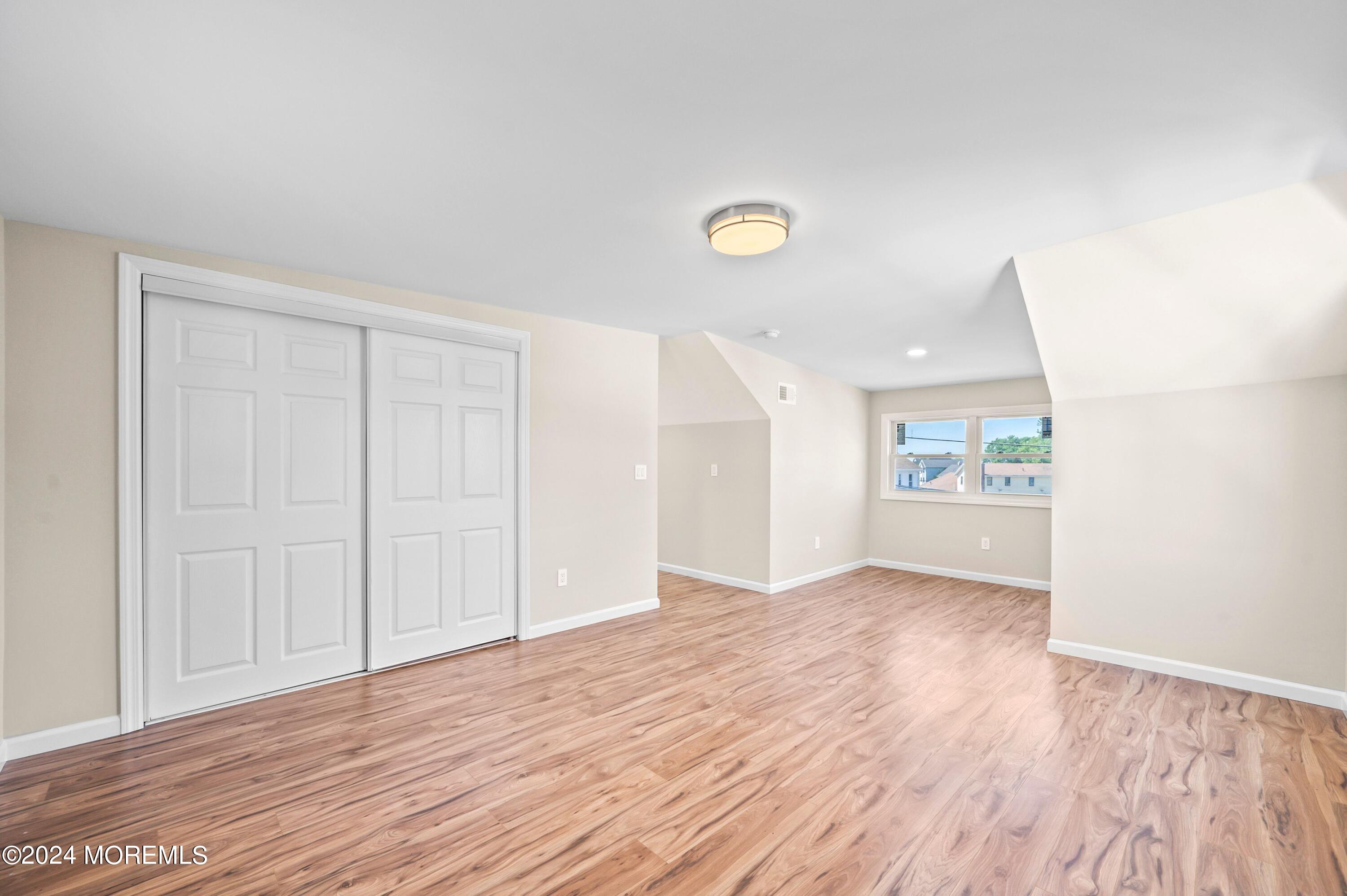 124 Victoria Place Union Beach, NJ 07735 - Photo 10 of 29 a view of an empty room with wooden floor and a window