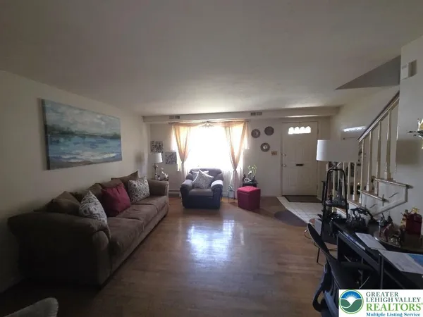 a living room with furniture and wooden floor