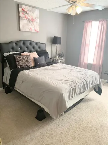 a large bed sitting in a bedroom next to a window