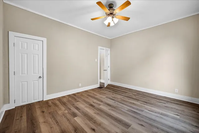 a view of an empty room with window and wooden floor