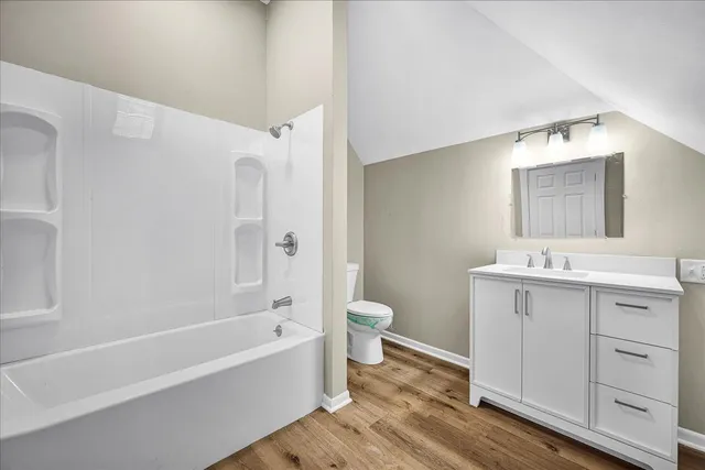 a bathroom with a granite countertop sink a toilet and shower