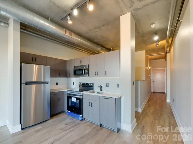a kitchen with refrigerator and cabinets