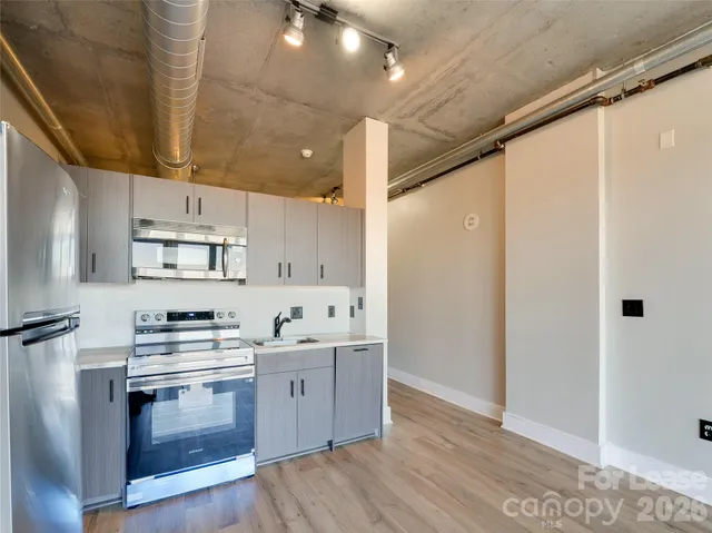 a kitchen with stainless steel appliances a stove a sink and a refrigerator