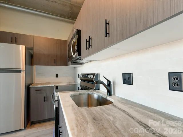 a kitchen with stainless steel appliances a sink a stove and a refrigerator