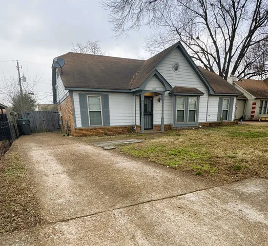 a front view of a house with a yard and trees