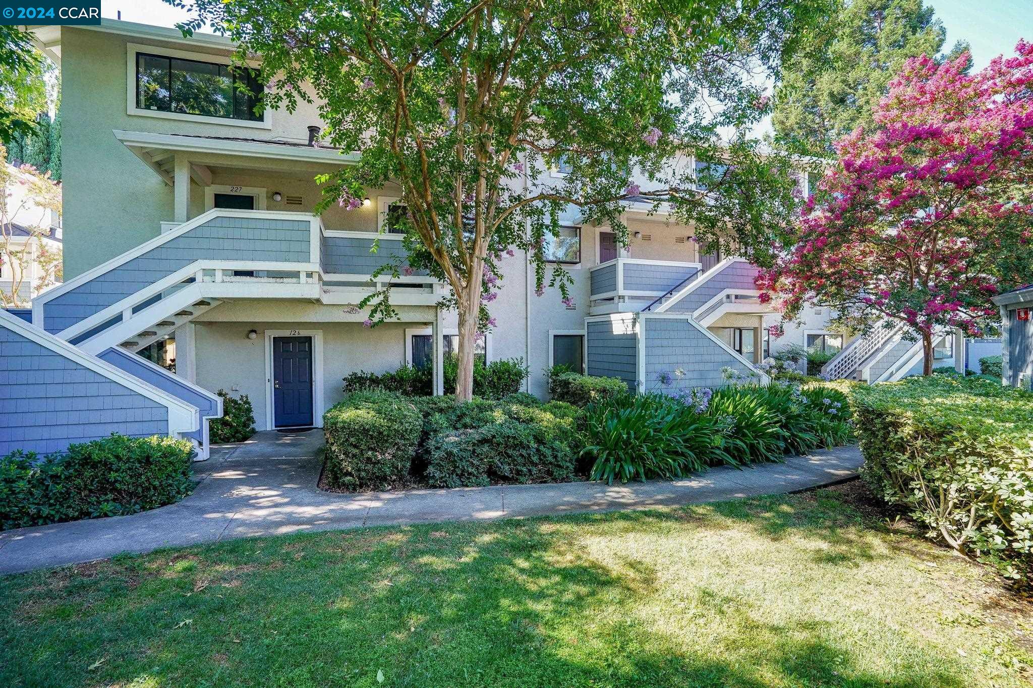 2584 Oak Road, Unit 224 Walnut Creek, CA 94597 - Photo 1 of 1 a front view of a house with a yard and potted plants