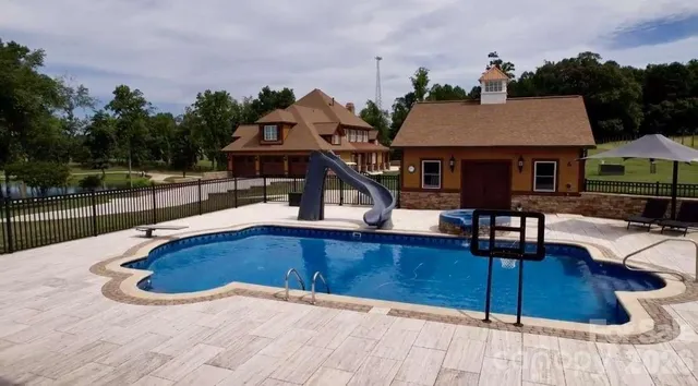 a view of a house with pool and chairs