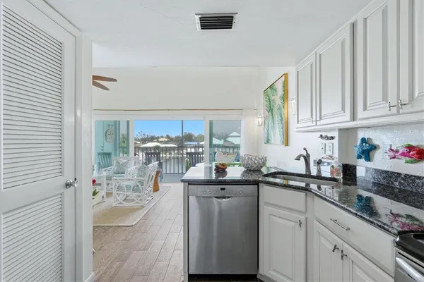 a kitchen with stainless steel appliances granite countertop a sink window and cabinets