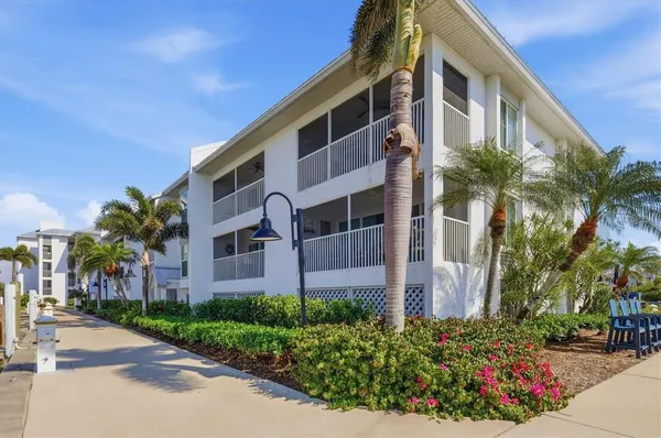 a front view of multi story residential apartment building with yard and sign board