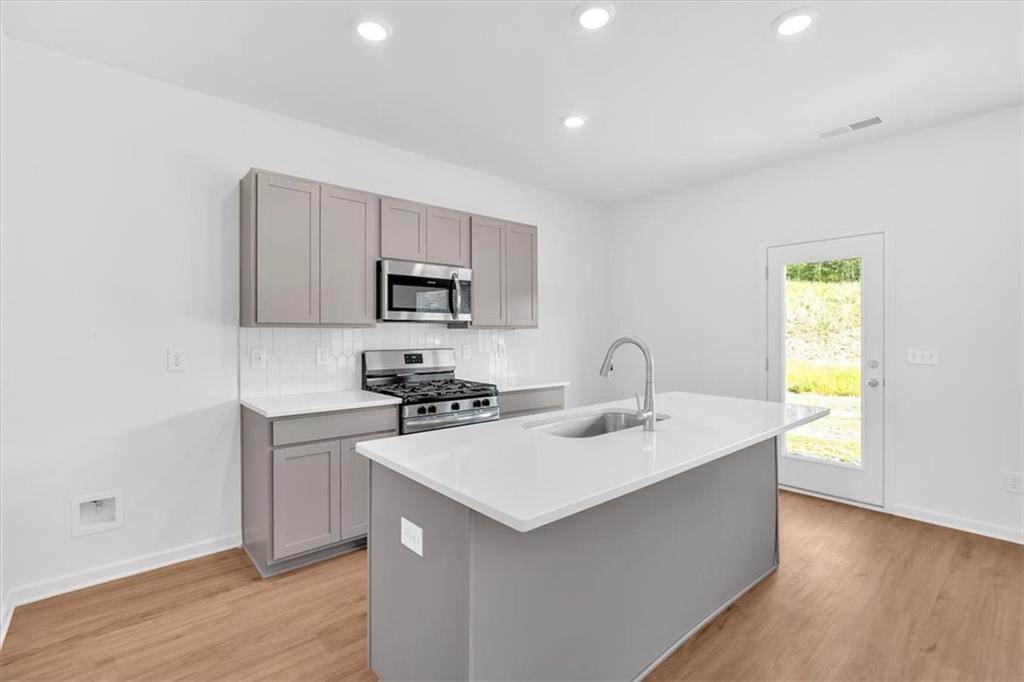 103 Lavender Circle Calhoun, GA 30701 - Photo 8 of 19 a kitchen with sink a microwave and stove