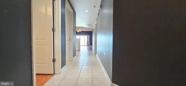 a hallway with wooden floor windows and a bathroom