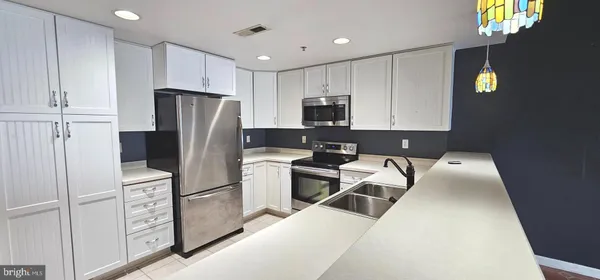 a kitchen with stainless steel appliances a refrigerator sink and cabinets