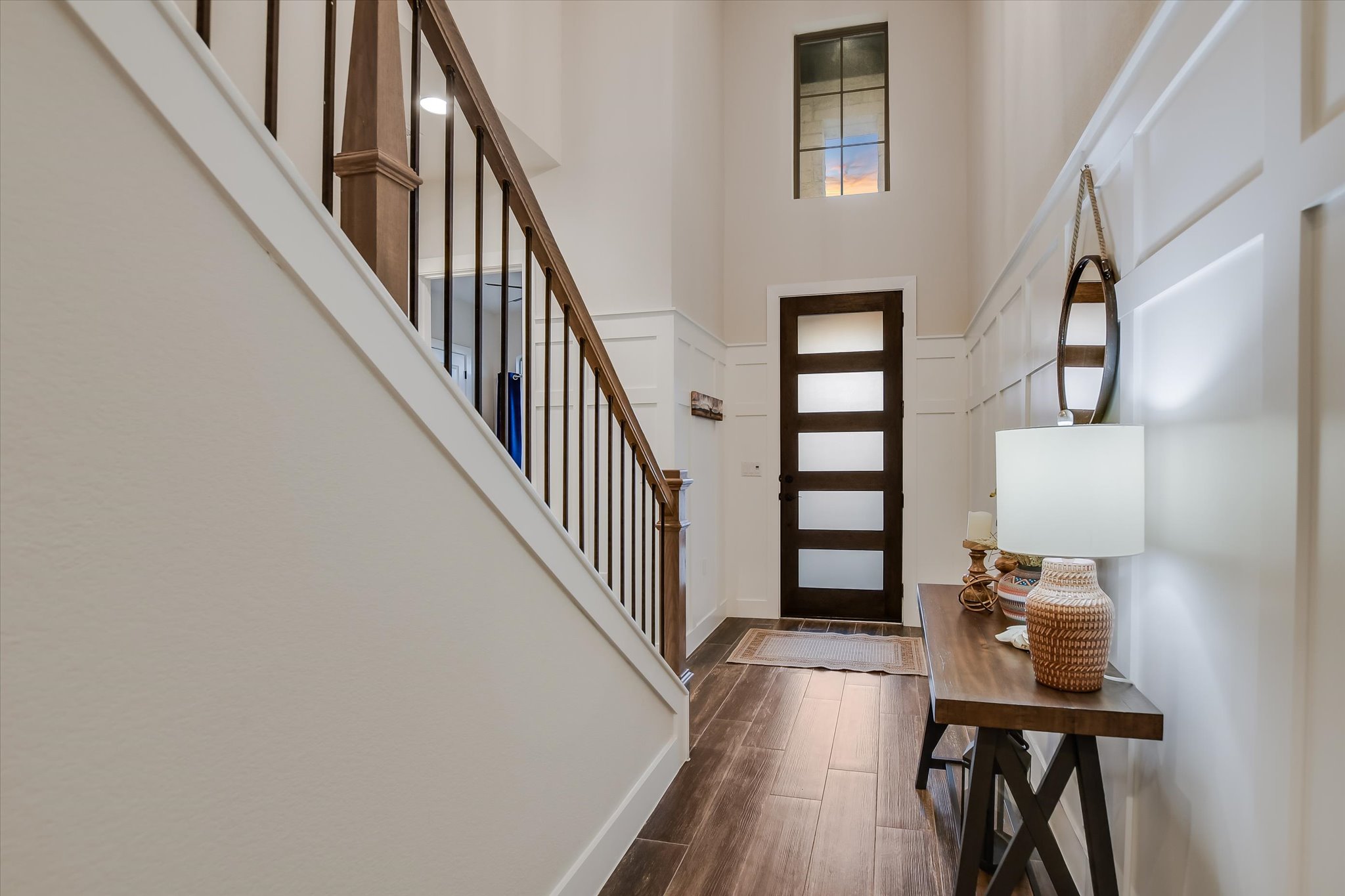 332 Axis Loop Georgetown, TX 78628 - Photo 5 of 37 Entryway with stairway, wood flooring, a towering ceiling, wainscoting, and a decorative wall