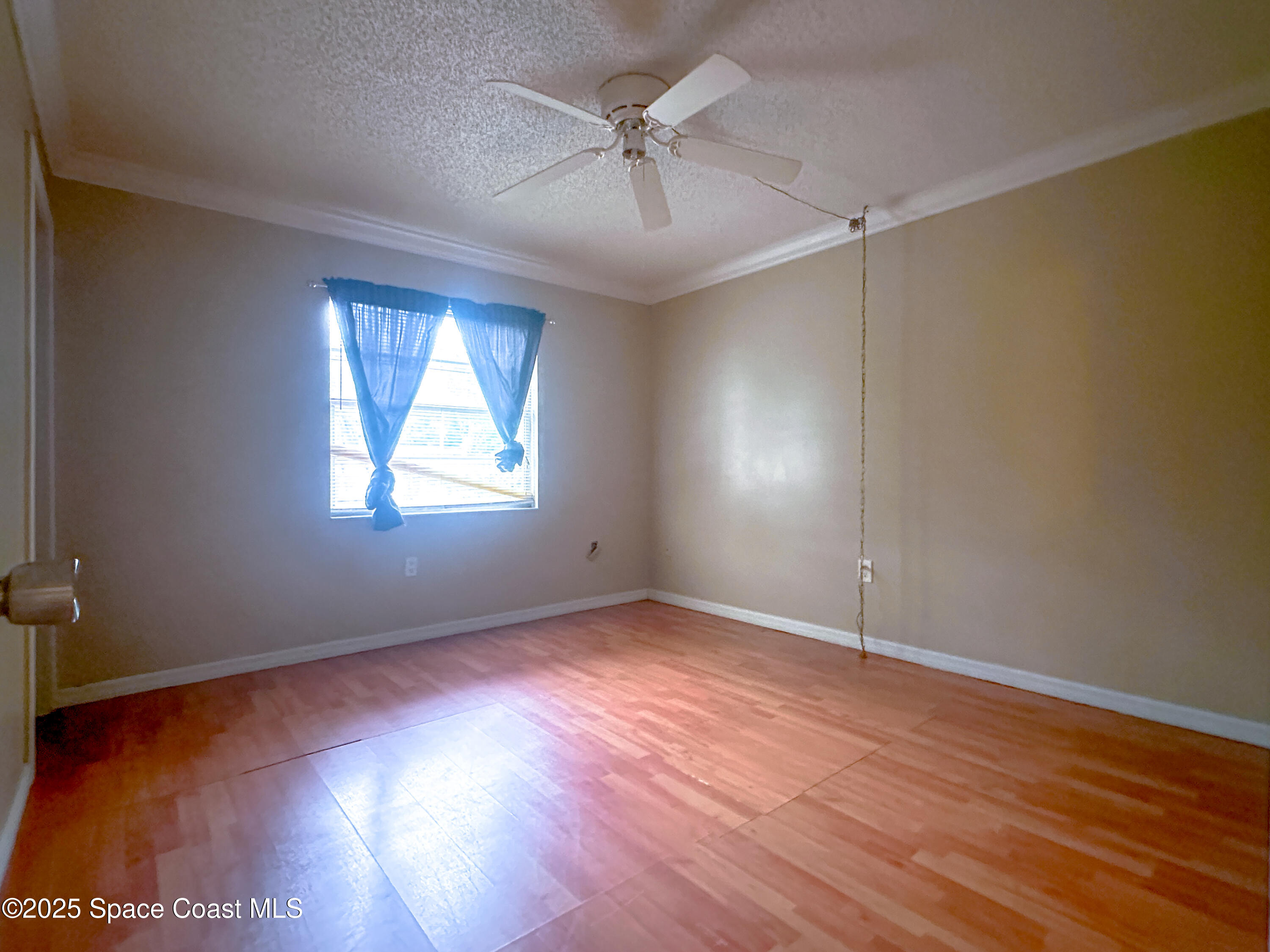 8215 Autumn Oak Avenue Port Richey, FL 34668 - Photo 20 of 21 an empty room with wooden floor chandelier fan and windows