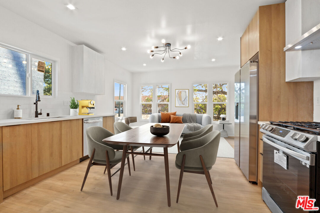 a kitchen with stainless steel appliances kitchen island granite countertop a table and chairs
