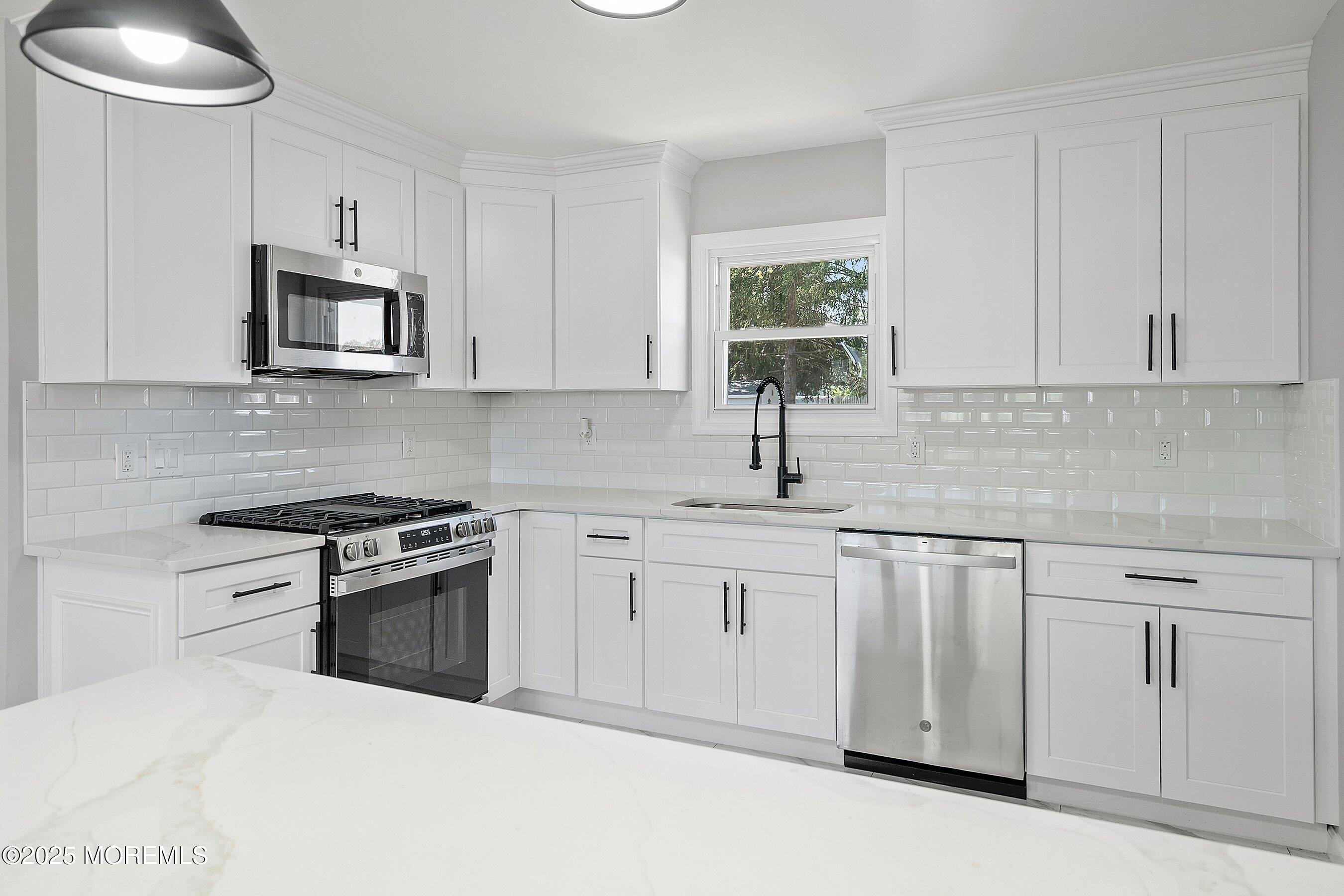 15 Springhill Drive Howell, NJ 07731 - Photo 11 of 32 a kitchen with white cabinets and stainless steel appliances
