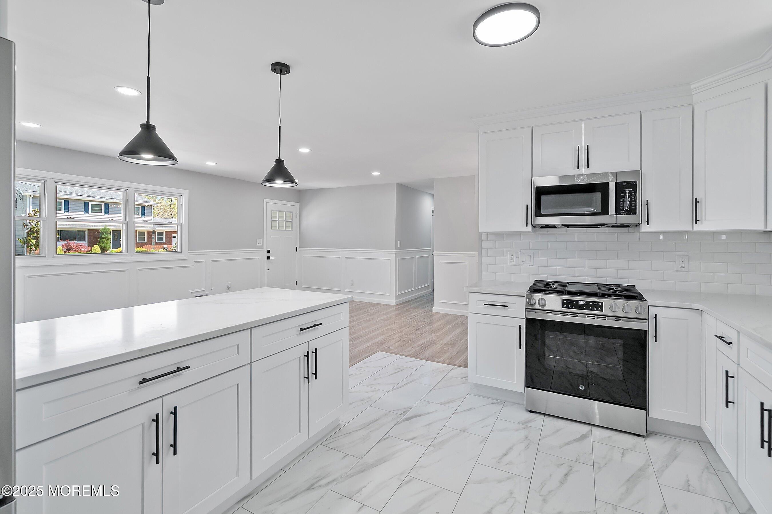 15 Springhill Drive Howell, NJ 07731 - Photo 14 of 32 a kitchen with stainless steel appliances granite countertop a stove a sink and a wooden floor