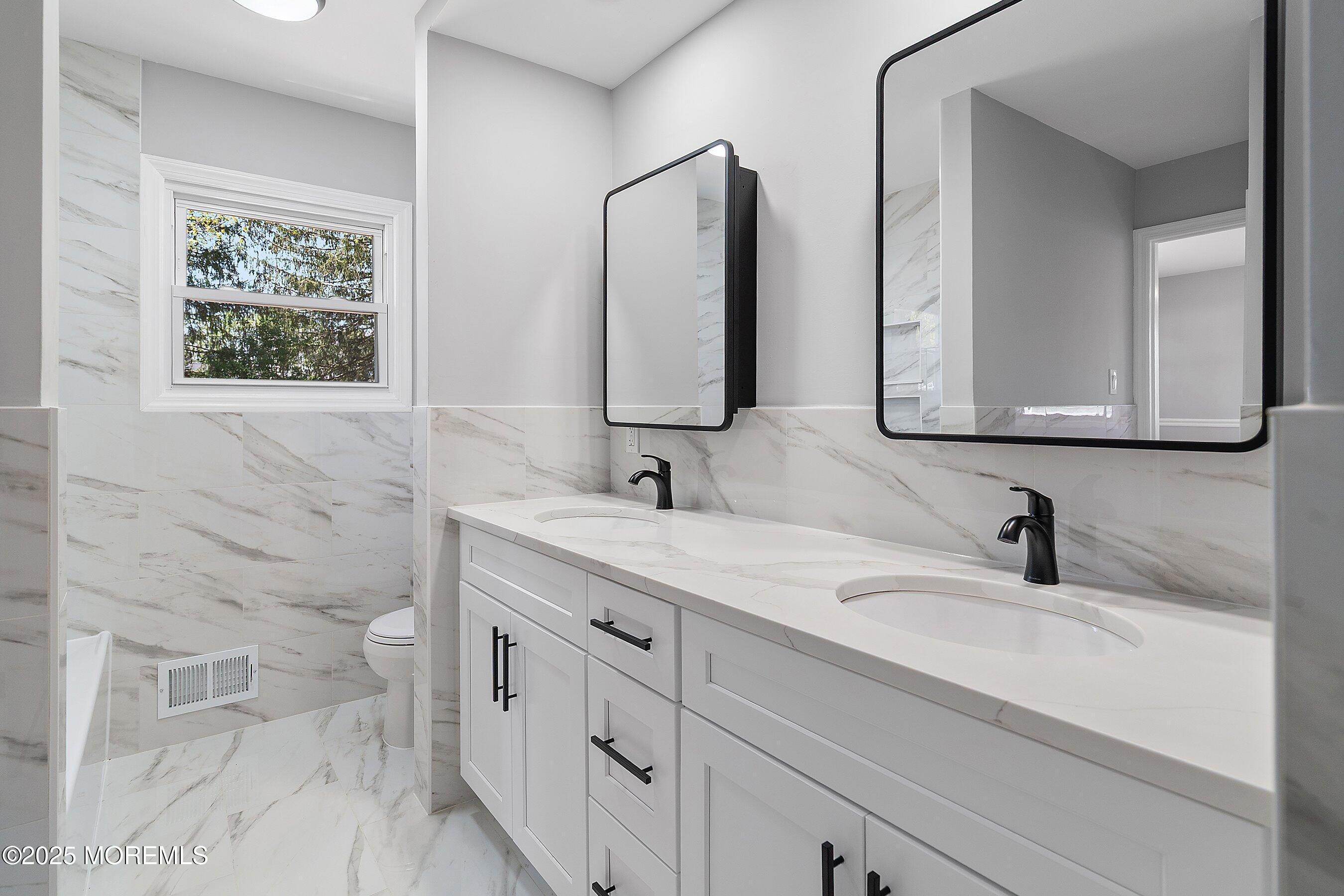 15 Springhill Drive Howell, NJ 07731 - Photo 18 of 32 a bathroom with a double vanity sink and a mirror