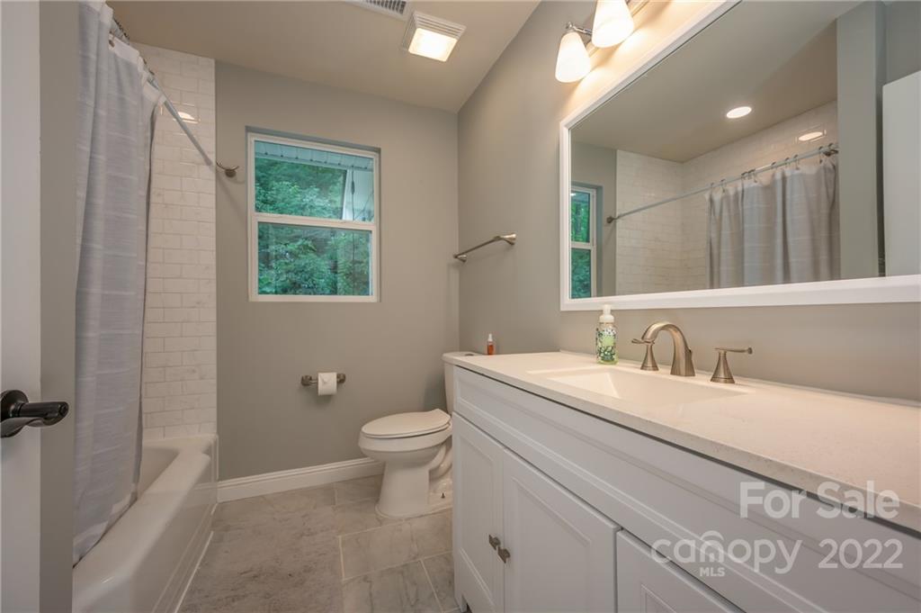 111 Jervey Road Tryon, NC 28782 - Photo 20 of 34 a bathroom with a granite countertop sink mirror vanity and toilet