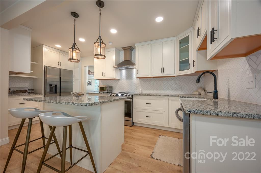111 Jervey Road Tryon, NC 28782 - Photo 3 of 34 a kitchen with stainless steel appliances granite countertop a sink a stove a refrigerator and island with wooden floor