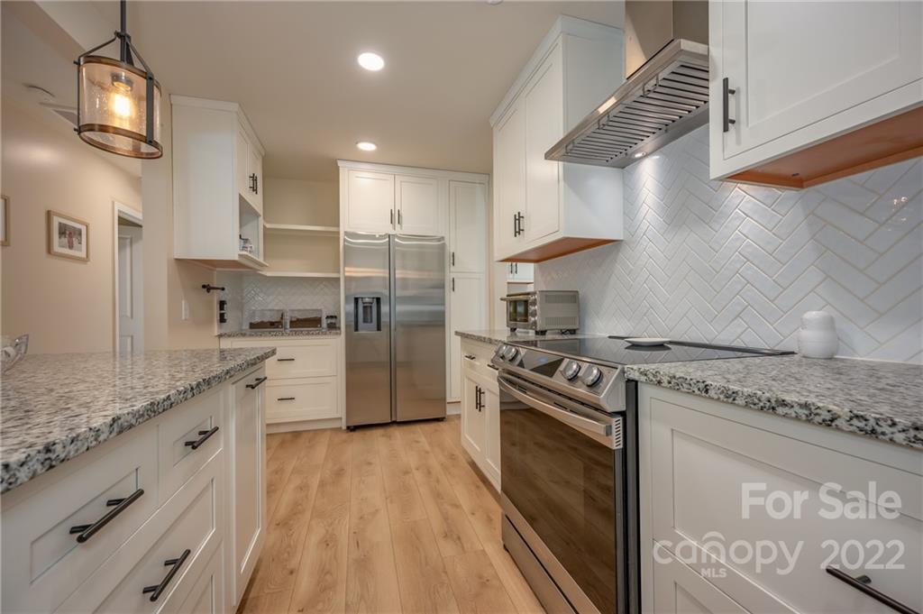 111 Jervey Road Tryon, NC 28782 - Photo 5 of 34 a kitchen with stainless steel appliances granite countertop a stove a refrigerator and a sink