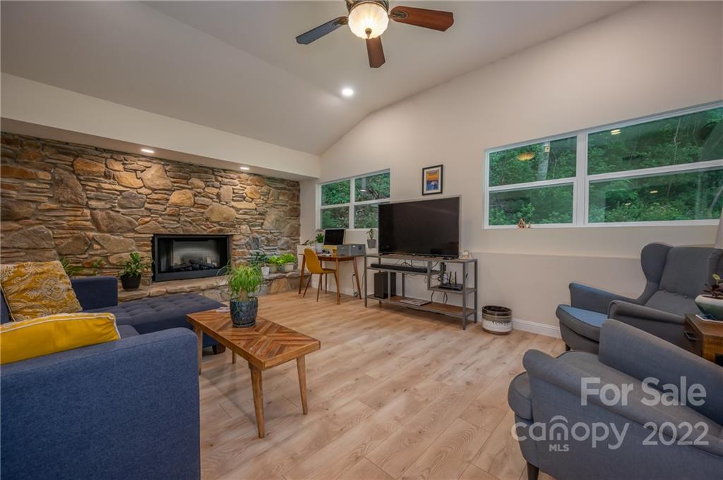111 Jervey Road Tryon, NC 28782 - Photo 10 of 34 a living room with furniture a fireplace and a flat screen tv