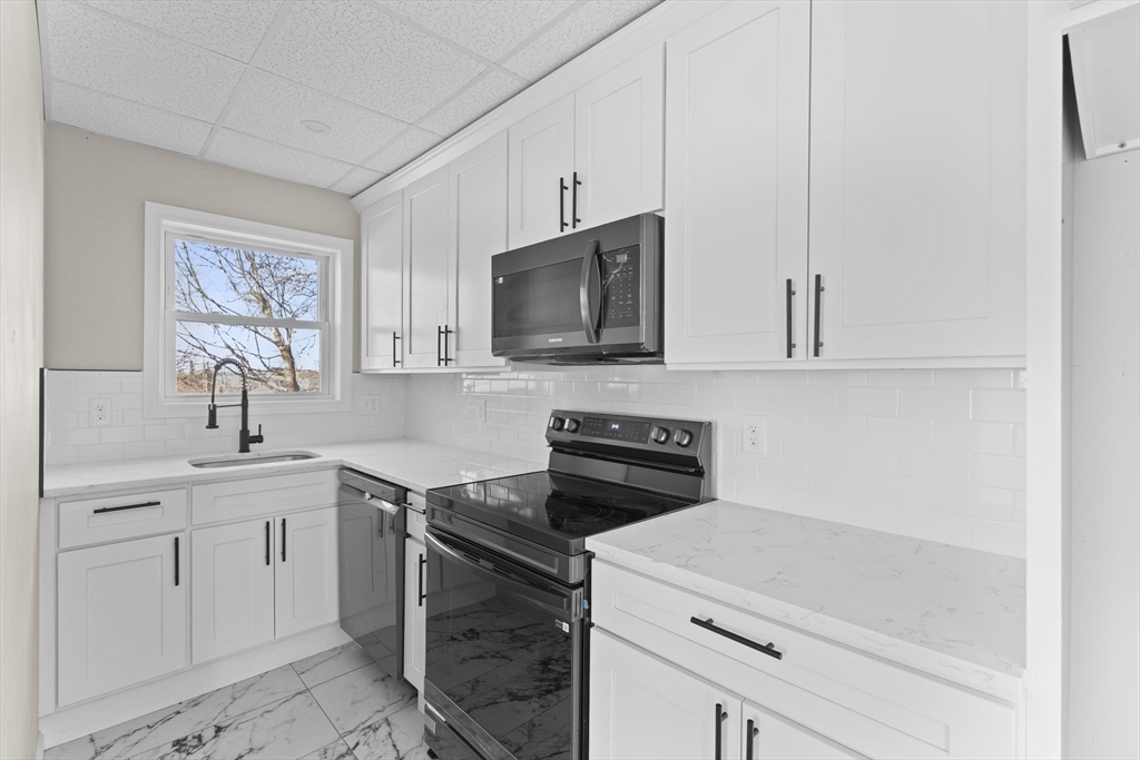 45 Garfield Street Fall River, MA 02721 - Photo 3 of 38 a kitchen with a sink stove and microwave