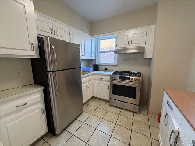 a kitchen with cabinets stainless steel appliances and a counter space