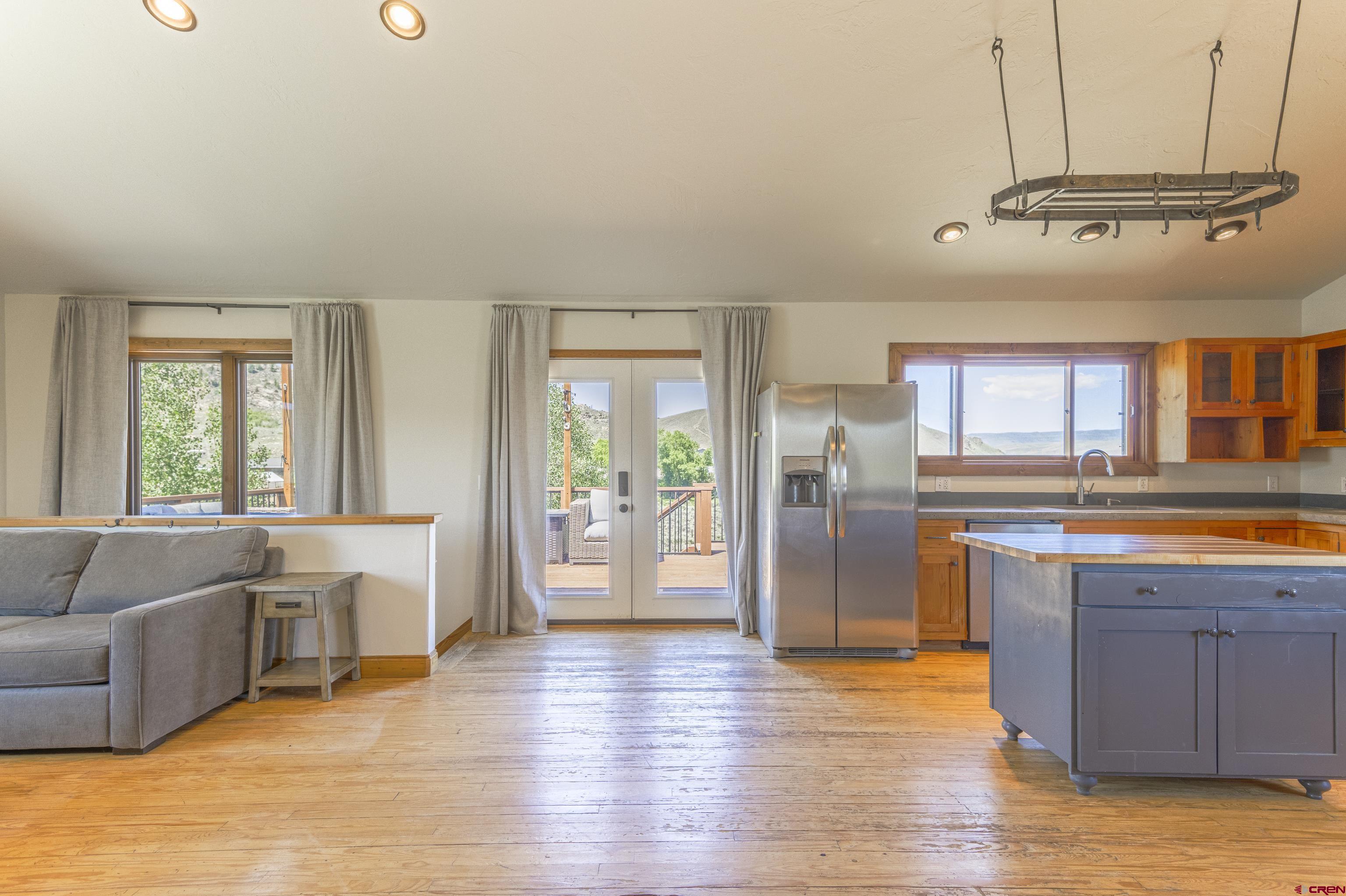 388 Columbine Road Gunnison, CO 81230 - Photo 22 of 45 a open kitchen with stainless steel appliances granite countertop a refrigerator a sink dishwasher a stove and white countertops with wooden floor