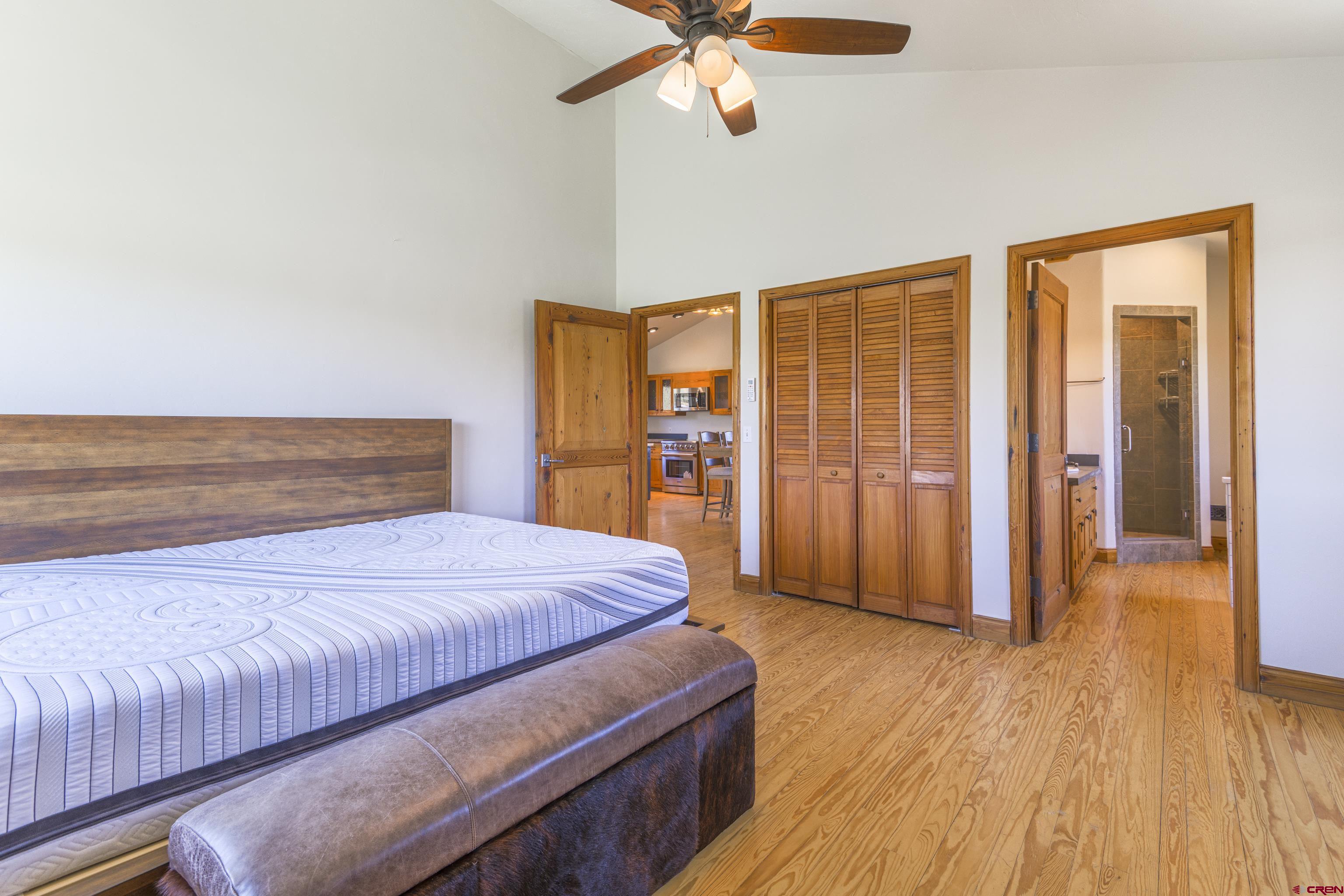 388 Columbine Road Gunnison, CO 81230 - Photo 27 of 45 a bedroom with a large bed and a chandelier