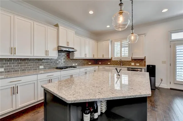 a spacious bathroom with a granite countertop sink a toilet a mirror and shower