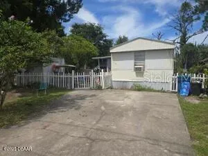 a view of a house with a yard and fence