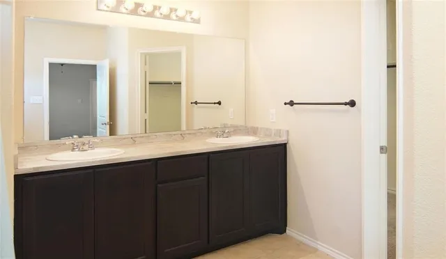 a bathroom with a double vanity sink and mirror