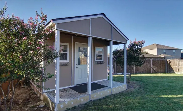 a backyard of a house with plants and wooden fence