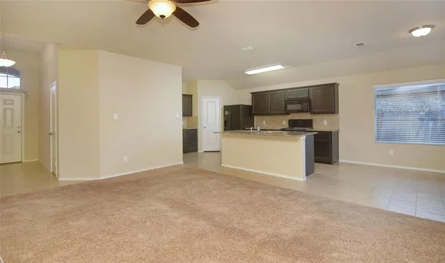 a view of kitchen with microwave oven stove and refrigerator