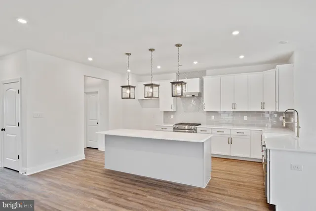 a large kitchen with stainless steel appliances lots of counter top space cabinets and a sink