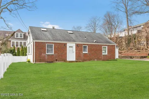 a view of a yard in front of a house with large tree