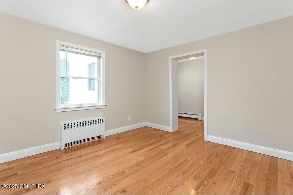 304 Valley Road Cos Cob, CT 06807 - Photo 8 of 21 an empty room with wooden floor cabinet and windows