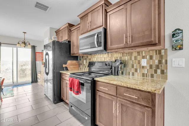 a kitchen with stainless steel appliances granite countertop a stove a sink and a microwave
